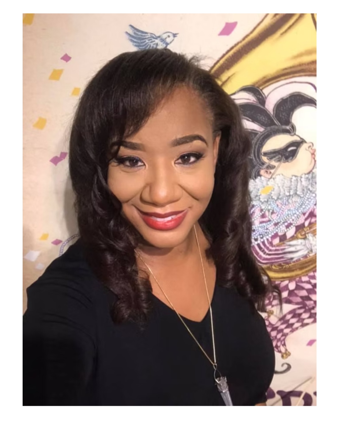 Ericka Boussarhane portrait with a jester mural backdrop
