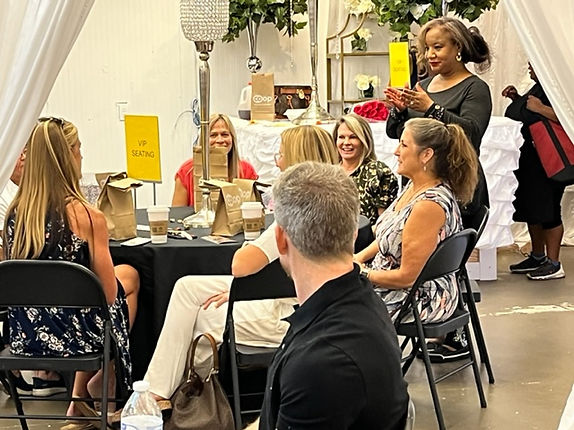 Ericka Boussarhane speaking to a seated audience at a live event